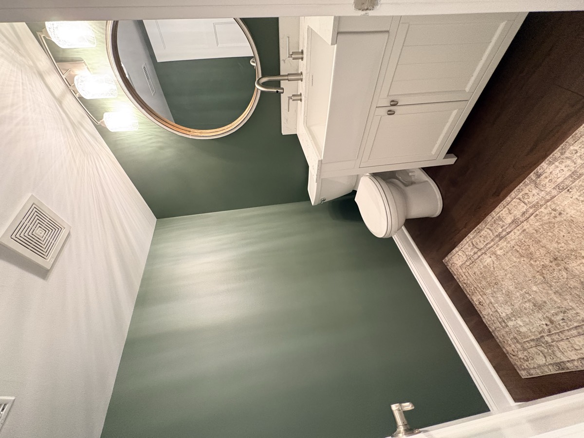 After — elegant green bathroom with white vanity and gold accents